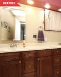 Bathroom with wooden cabinets, dual sinks, purple towel, and beige walls under recessed lighting.