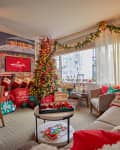 Festive living room with Christmas tree, gifts, garlands, and cozy seating, featuring Hallmark Channel decor.