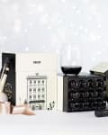 Vinebox wine tasting set with two glasses, one red and one white, alongside decorative holiday packaging.