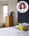 Bedroom with white dresser, yellow flowers, wooden chair, and a bed with a yellow pillow.