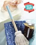 Mop with a blue handle, jar with ribbon, and blue patterned paper, labeled "Homemade Holiday Gift Idea Exchange."