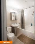 Small bathroom with white fixtures, patterned shower curtain, wall mirror cabinet, and beige floor mat.