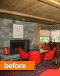 Living room with stone fireplace, red chairs, blue sofa, and wooden ceiling, featuring colorful artwork and floral carpet.