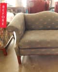 Vintage loveseat with curved arms and floral upholstery in a room with assorted furniture.