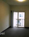 Empty room with sliding glass doors, gray carpet, and white walls.