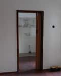 Empty room with wooden floor, open window, and doorway leading to a tiled area. Red "Before" label on the left.