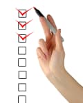 Hand holding a red marker, checking off three boxes on a vertical checklist.