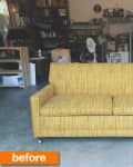 Yellow vintage sofa on a concrete floor in a cluttered garage with shelves and tools.