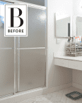 Bathroom with white vanity, large mirror, shower stall, and countertop with toiletries and makeup organizer.