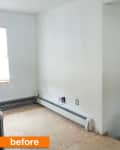 Empty room with white walls, exposed baseboard heater, and plywood floor, labeled "before" in orange.