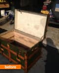 Open vintage trunk with green and brown exterior in a garage setting.