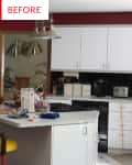 Cluttered kitchen with white cabinets, black backsplash, and red walls, featuring a countertop with various items.
