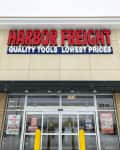 Harbor Freight storefront with red and blue signage, glass doors, and sale posters.