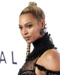 Woman in a black beaded dress with a high ponytail at a Tidal event.