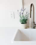 A white sink with a single handle is running