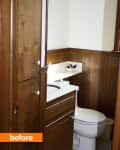 Small bathroom with wood paneling, white toilet, and vanity with a blue sink.