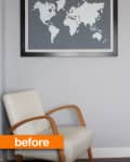 Cream armchair with wooden arms beneath a framed world map on a gray wall.