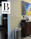 Kitchen corner with a wooden cart, mixer, abstract painting, and stainless steel trash can.