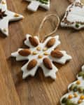 Salt dough ornaments with almonds, seeds, and corn kernels on a wooden surface.