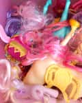 Pile of colorful toy ponies with tangled pink and purple manes.