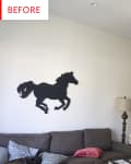 Living room with gray sofa, horse wall art, wooden dining table, chairs, and plants near a window.