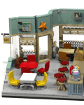 Lego model of a cafe with red and yellow chairs, tables, counter, and wall decor including a starfish and framed pictures.