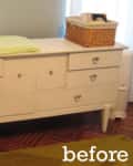 White dresser with multiple drawers, wicker baskets, and a green changing pad on top.