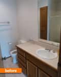 Small bathroom with wooden vanity, single sink, toilet, and shower.