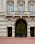Grand entrance of a historic building with a large decorated Christmas tree under an archway.