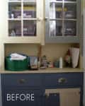 Cluttered kitchen cabinet with glass doors, various containers, and cleaning supplies.