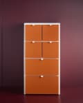 Tall orange storage cabinet with six compartments against a dark red wall.