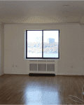 Empty room with hardwood floors, large window, and white walls, labeled "Before" in the top left corner.