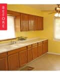 Yellow kitchen with wooden cabinets, white countertops, ceiling fan, and tiled floor.