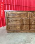 Wooden dresser with ornate drawer fronts against a red corrugated wall.
