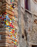 Old stone wall repaired with colorful LEGO bricks.