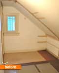 Small attic room with slanted ceiling, beige walls, and a small window with grid pattern.