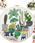 Embroidery hoops with various potted plants and cacti designs, held by hands.