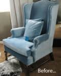 Blue velvet wingback chair with matching cushion in a room with beige carpet and curtains.