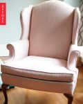 Pink wingback chair with wooden legs on a hardwood floor, labeled "Before."