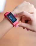 Person checking a pink fitness tracker displaying a heart rate of 131 bpm.