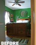 Green bedroom with wooden bed, moon and star wall decor, ceiling fan, and striped rug.