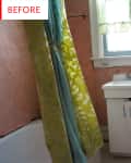 Small bathroom with pink tiles, white sink, toilet, and green shower curtain.