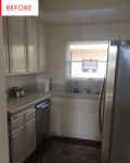 Narrow kitchen with white cabinets, stainless steel appliances, and a patterned rug.