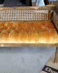 Vintage wooden bench with orange tufted cushion and woven backrest, labeled "before."