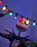 Skeleton character holding colorful Christmas lights in a festive setting.