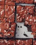 Fudgy chocolate brownies with a shiny, cracked top, cut into squares.