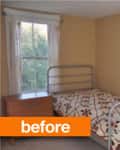 Small bedroom with metal bed frame, floral bedspread, wooden nightstand, and two windows with sheer curtains.