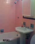 Pink tiled bathroom with pedestal sink, bathtub, and wall-mounted mirror cabinet.