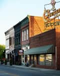 Historic downtown street with brick buildings, awnings, and a vintage ice cream sign.