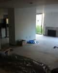 Unfurnished living room with carpet, fireplace, sliding glass door, and unpacked boxes.